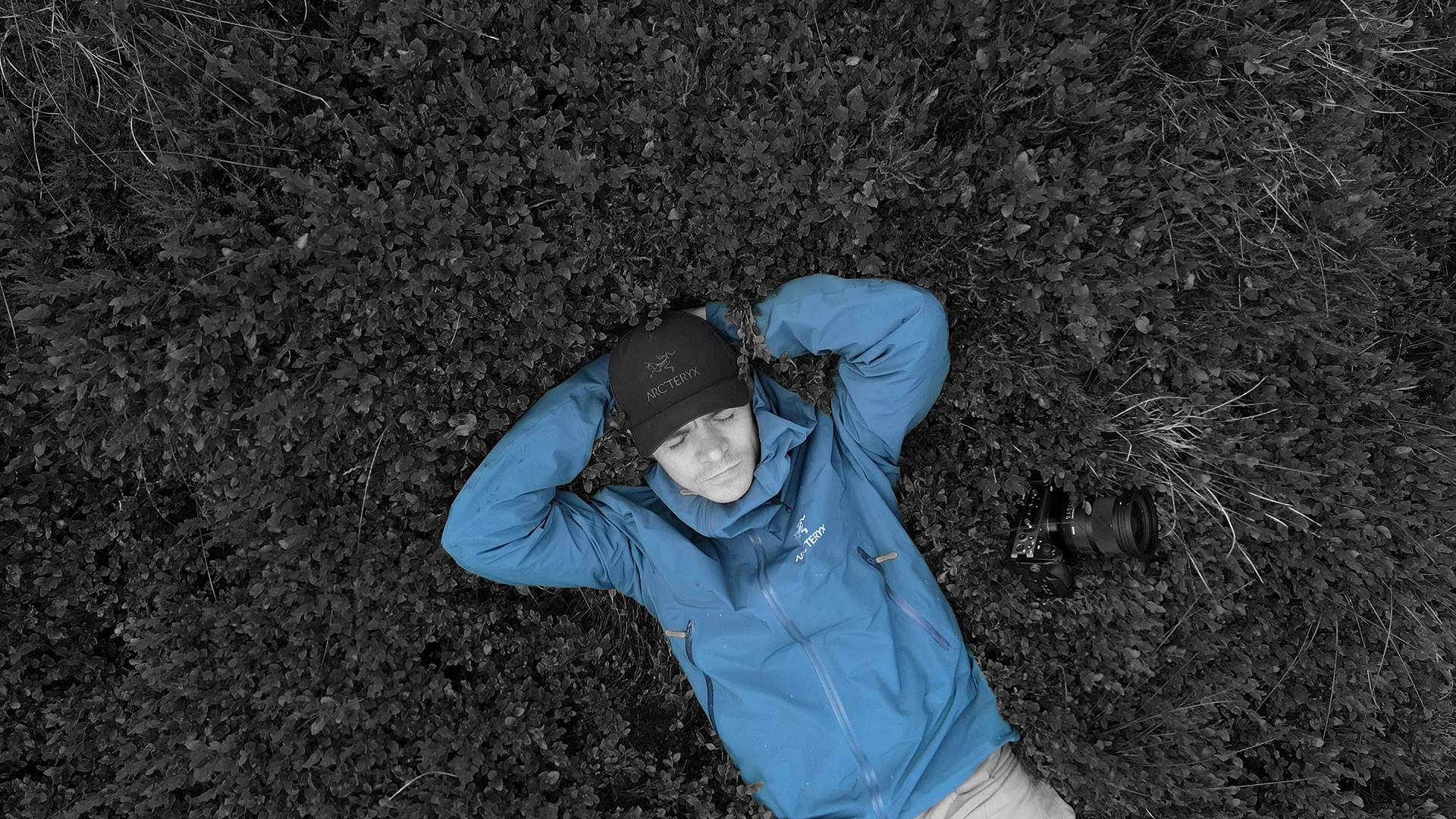 Scott Green lying on grass beside camera in Saddleworth, reflective outdoor portrait for MUVE®.